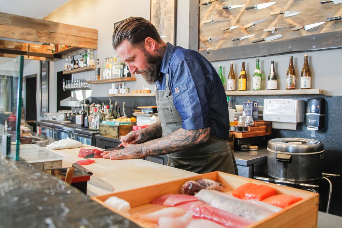 In this 2018 photo, chef Rob Ruiz prepares a hand roll made with locally caught tuna at his now-shuttered Land & Water Co. restaurant in Carlsbad.