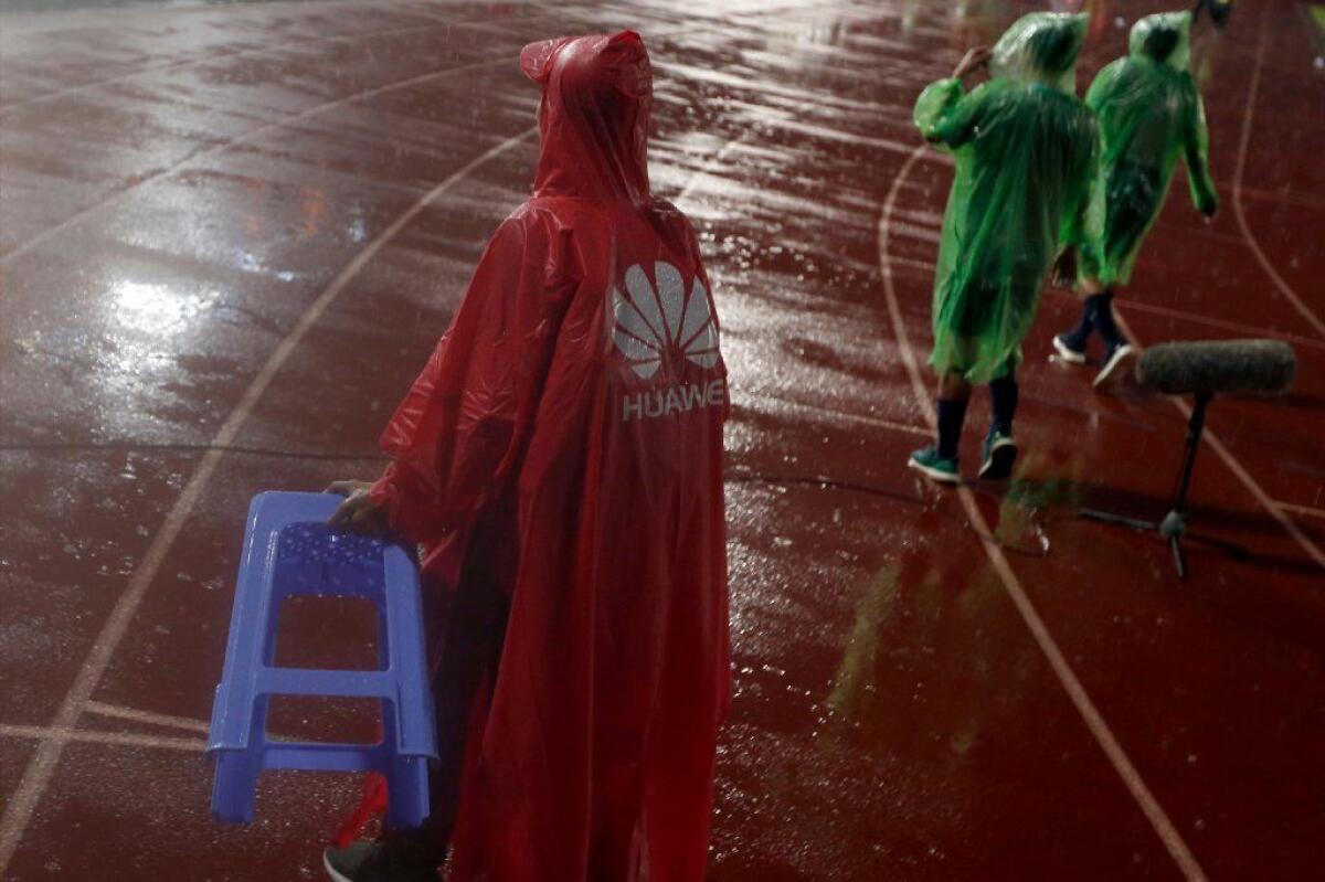 A man wears a raincoat bearing a Huawei logo in Phnom Penh, Cambodia's capital. Cambodia is among the countries that have signed agreements with Huawei and rivals to develop 5G networks.