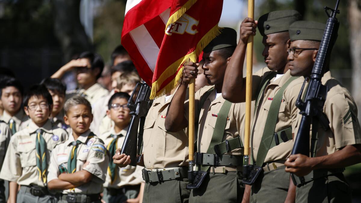 Boy Scouts watch as the Marine color guard participates in a ceremony honoring the fallen heroes.