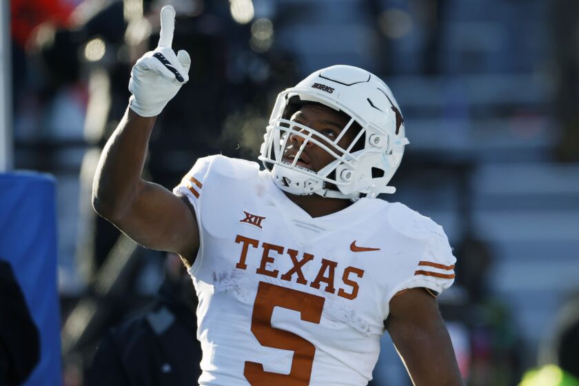 FILE - Texas running back Bijan Robinson reacts after scoring against Kansas during the first half of an NCAA college football game on Saturday, Nov. 19, 2022, in Lawrence, Kan. Robinson was selected to The Associated Press All-America team released Monday, Dec. 12, 2022. (AP Photo/Colin E. Braley, File)