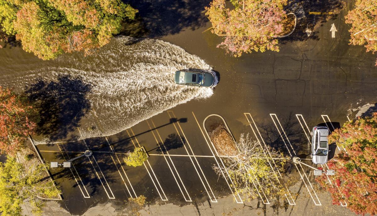 A car crosses a flooded parking lot in Oroville, Calif.