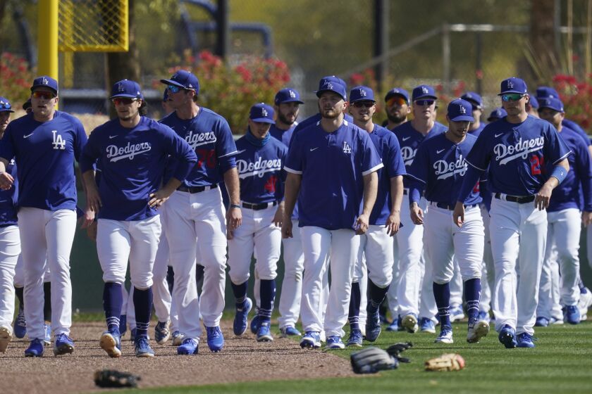 Los Angeles Dodgers players walk back to the infield after running sprints during a spring training baseball practice Tuesday, Feb. 23, 2021, in Phoenix. (AP Photo/Ross D. Franklin)