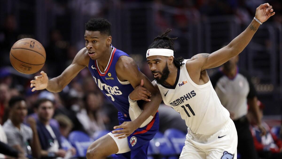 Clippers guard Shai Gilgeous-Alexander battles Grizzlies guard Mike Conley (11) for possession of a loose ball during the second half Friday.