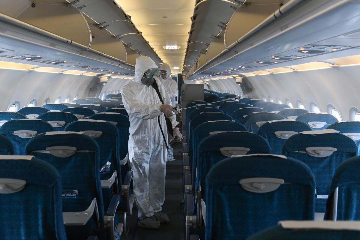 Workers disinfect a Vietnam Airlines plane to guard against coronavirus at Noi Bai International Airport in Hanoi.