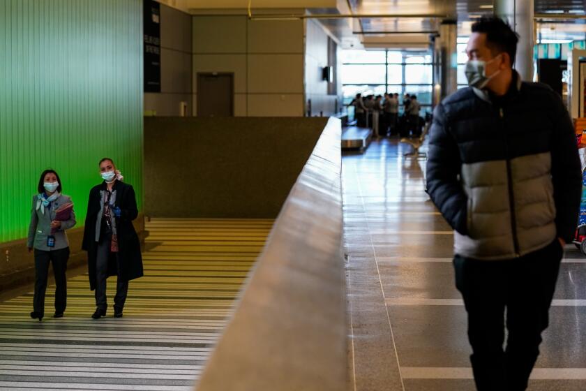 LOS ANGELES, CA - MARCH 18: People walk up the ramp, exiting the secure area at the Tom Bradley International Terminal at LAX on Wednesday, March 18, 2020 in Los Angeles, CA. (Kent Nishimura / Los Angeles Times)