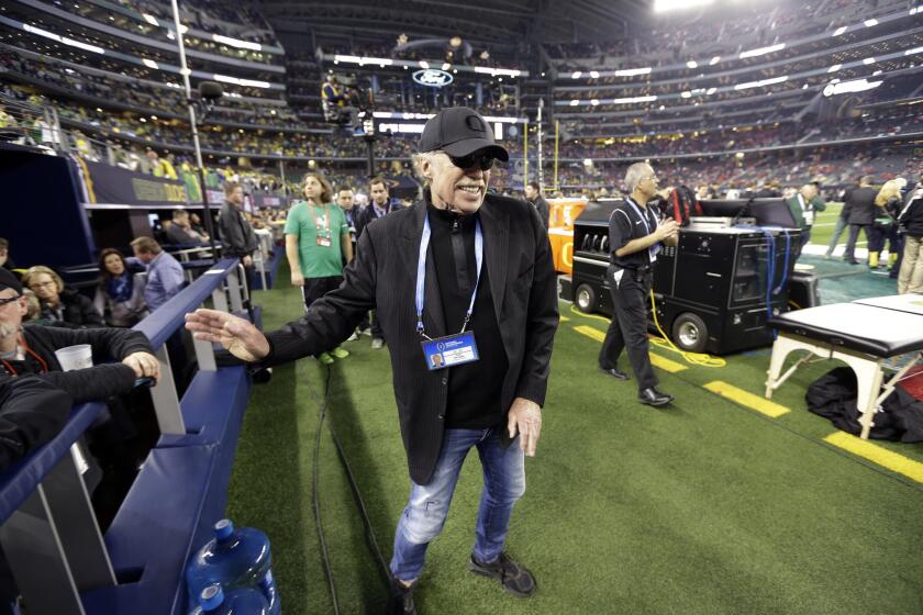 Nike Chairman Phil Knight walks near the field before the NCAA college football playoff championship game between Ohio State and Oregon in Arlington, Texas.