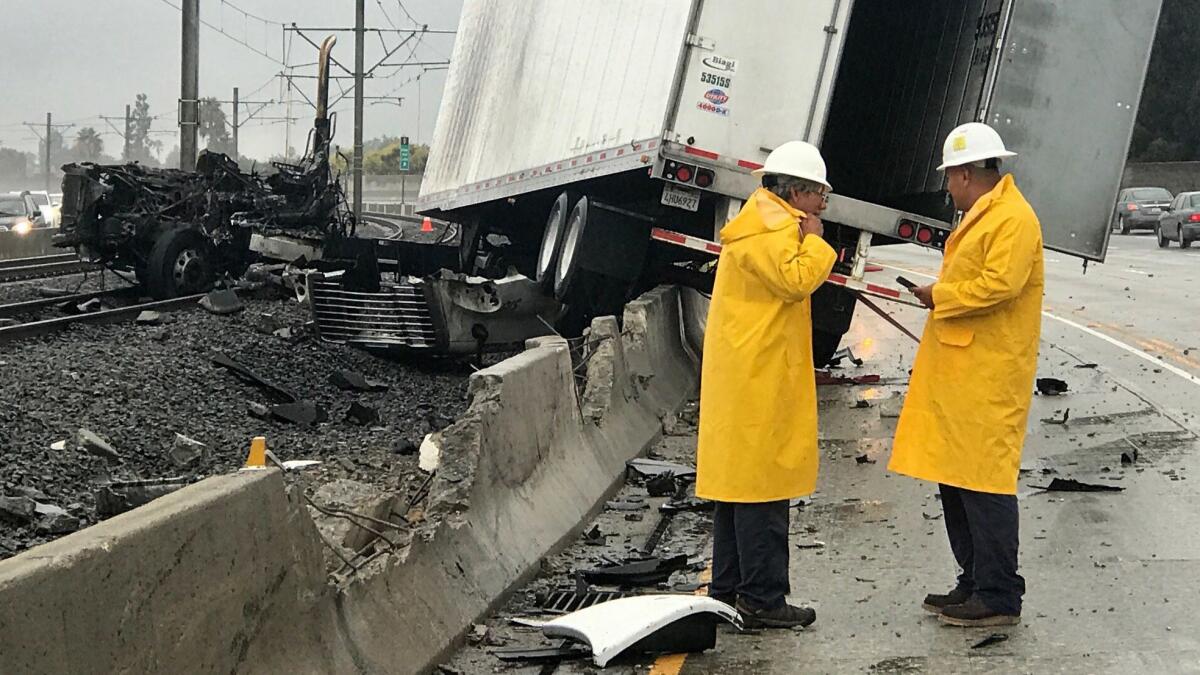 After hitting and crossing the center divider on the westbound 210 freeway, a truck caught fire and came to rest on the Gold Line Metro tracks.