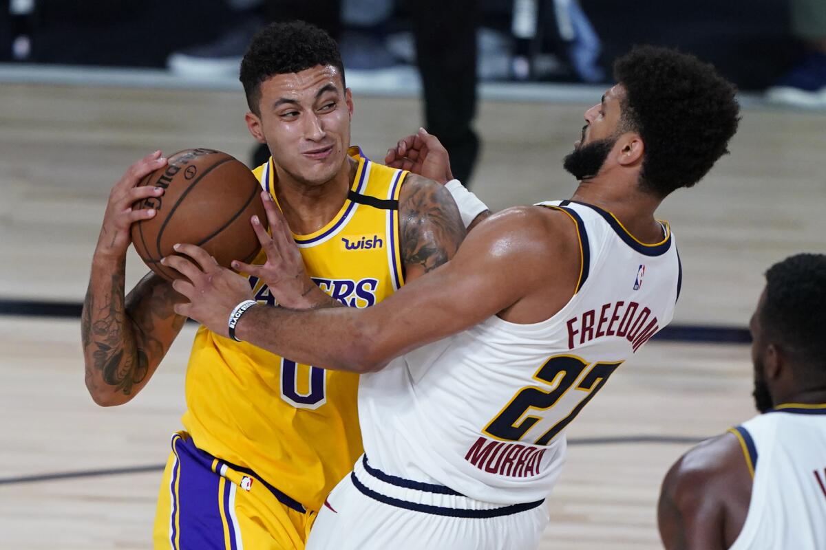 The Lakers' Kyle Kuzma drives to the basket against Denver Nuggets' Jamal Murray on Aug. 10 in Lake Buena Vista, Fla. 