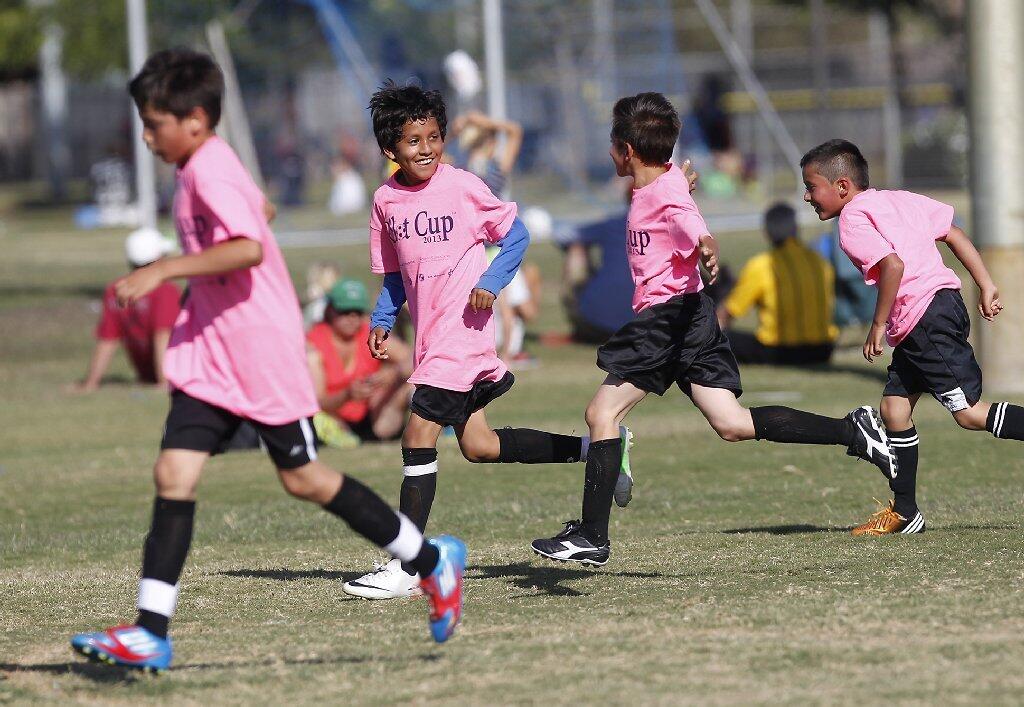 Whittier's Christian Adame, second from left, runs down the field with his teammates after scoring a goal against Paularino during a boys' 3-4 gold division game.