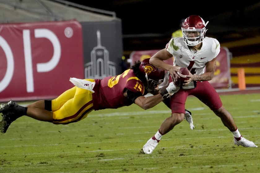 Southern California safety Talanoa Hufanga, left, pulls down Washington State quarterback Jayden de Laura for a sack during the first half of an NCAA college football game in Los Angeles, Sunday, Dec. 6, 2020. (AP Photo/Alex Gallardo)