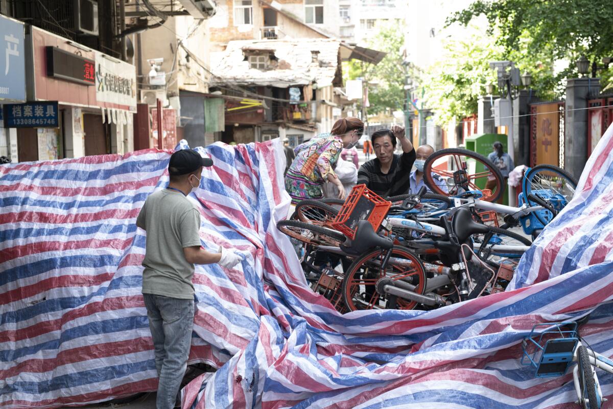 A makeshift barricade of rental bikes and plastic tarpaulin blocks a road in Wuhan. Roadblocks had been part of the lockdown and had finally been removed when the restrictions ended.