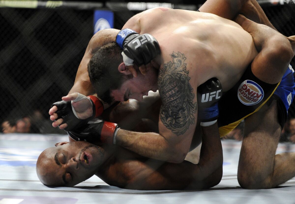 Chris Weidman, top, punches Anderson Silva during their middleweight title fight at UFC 168 in Las Vegas on Saturday.
