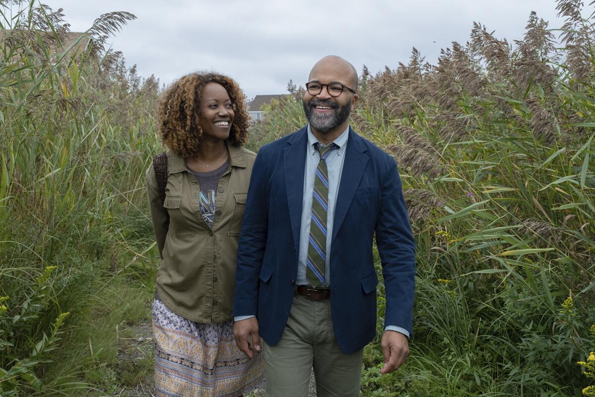 A man and woman walk amid tall grasses in "American Fiction."
