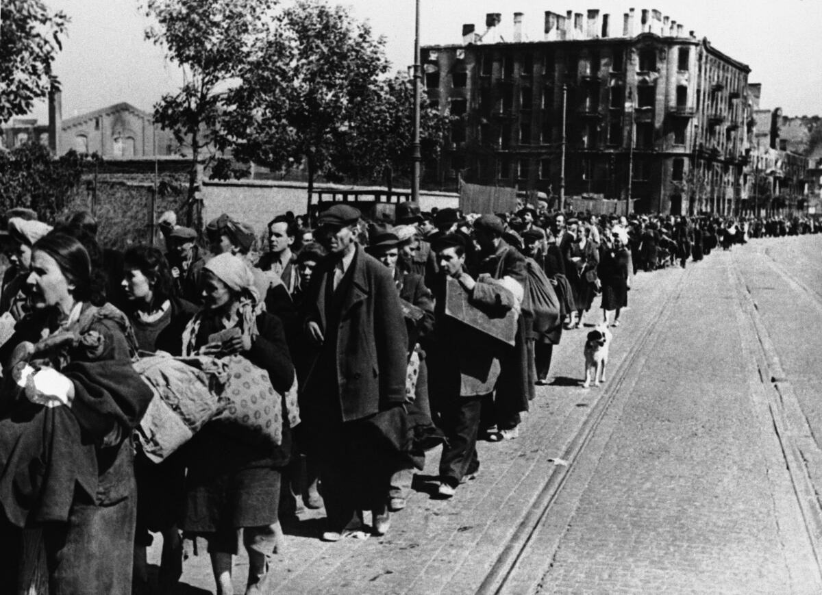 Long columns of Polish men and women move through the streets of Warsaw to less destroyed areas Sept. 15, 1944.