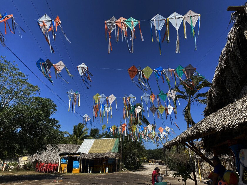 Thatched-roof shops and colorful flags are seen in San Blas, Mexico.