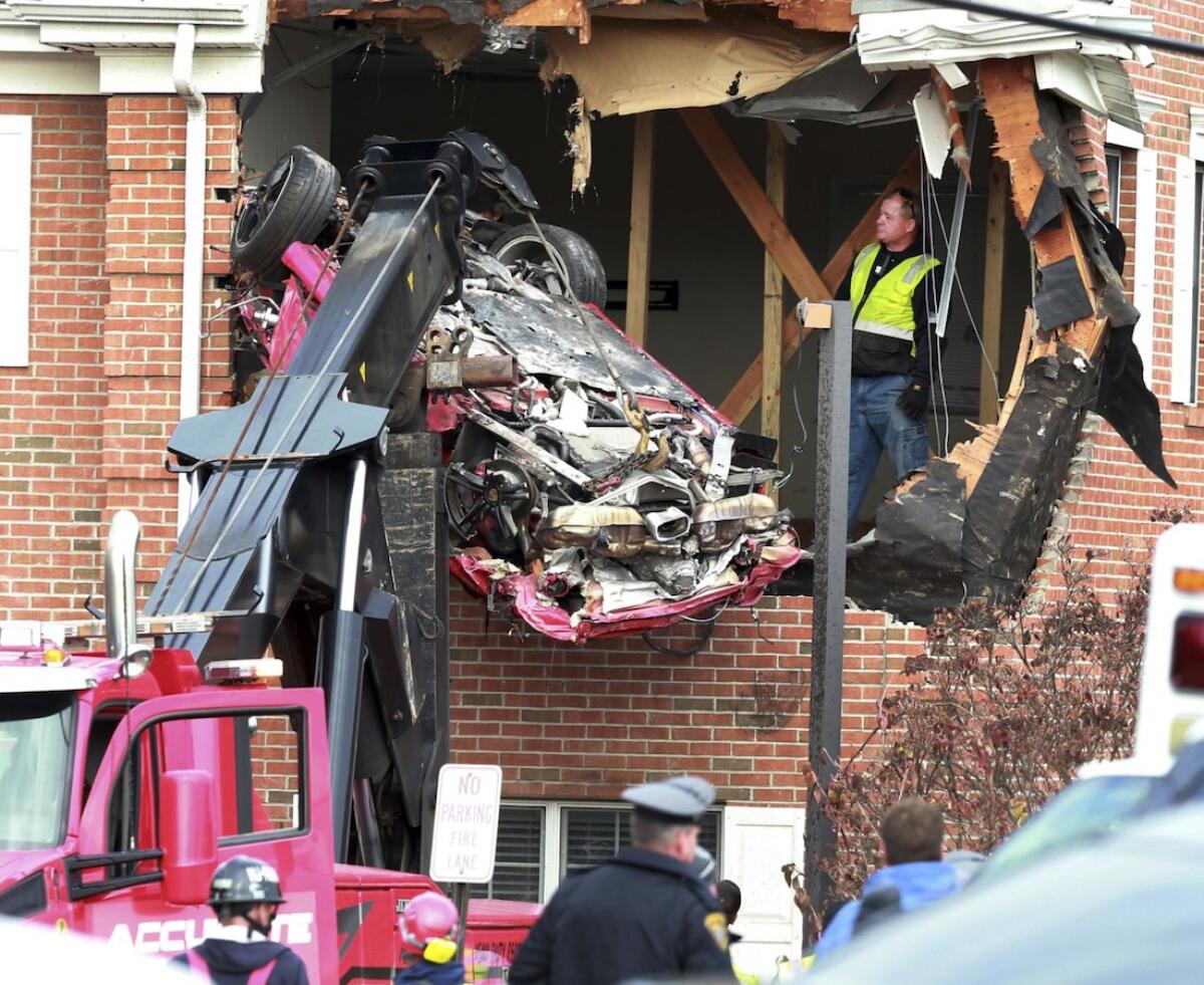 Los restos de un Porsche son retirados de un edificio después de que el vehículo se elevó por el aire y se metió al segundo piso, en Toms River, Nueva Jersey.