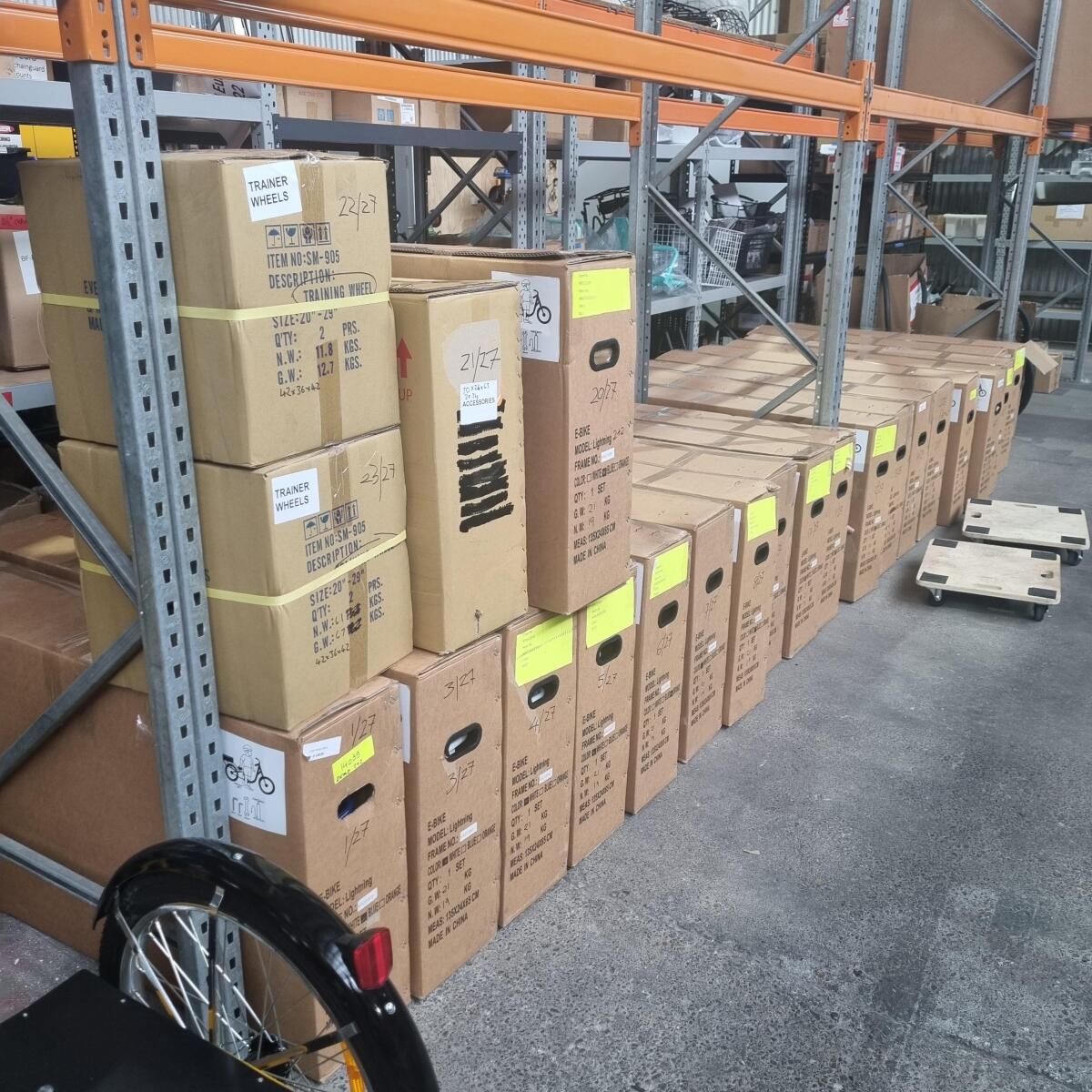 Several boxes are clustered on a metal warehouse shelf.