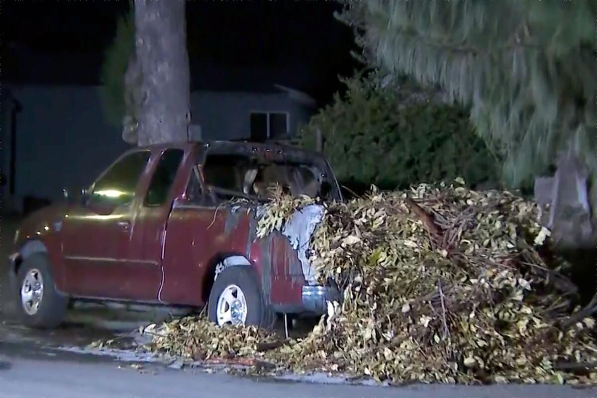 A truck is damaged and covered with debris.