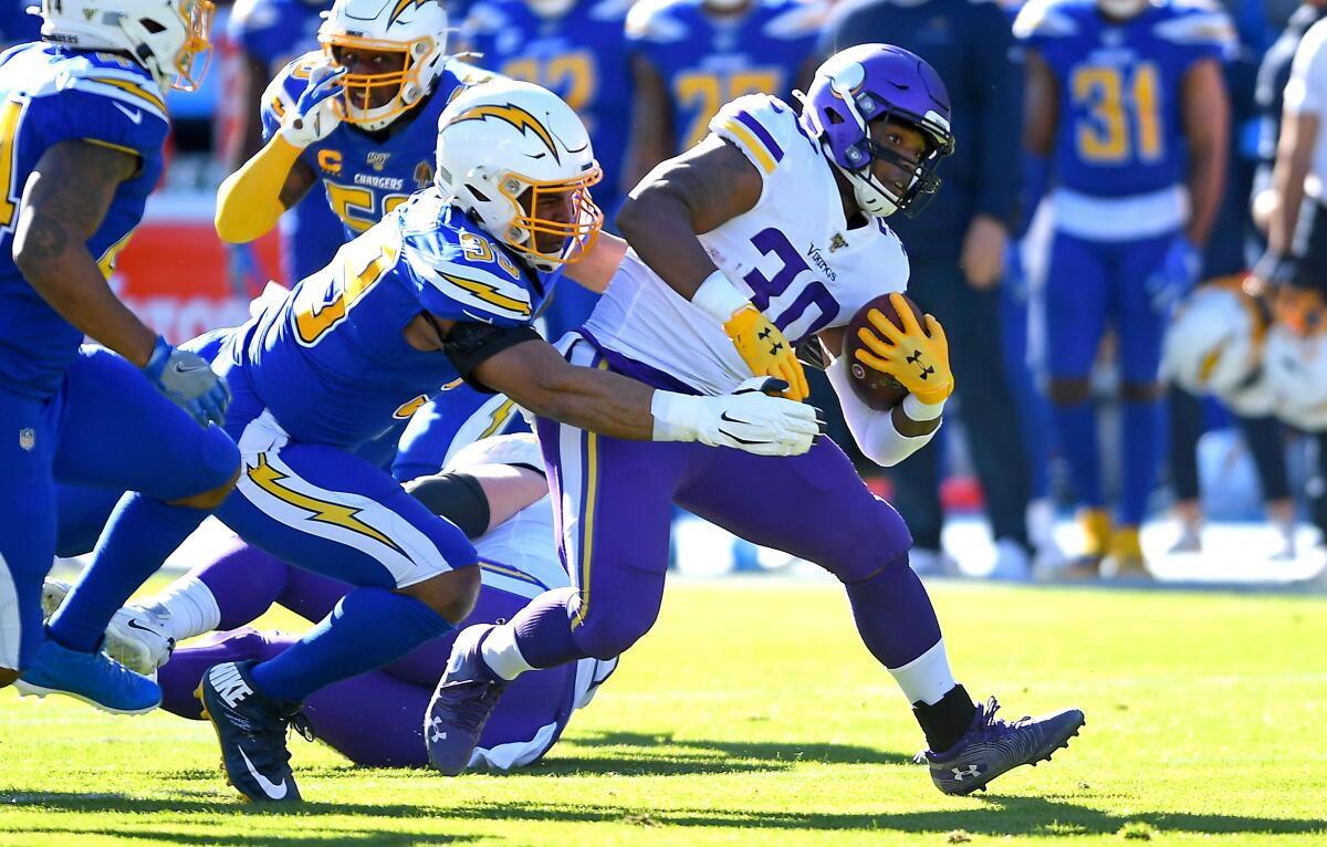Chargers safety Derwin James, left, tackles Minnesota Vikings fullback C.J. Ham during a game on Dec. 15.