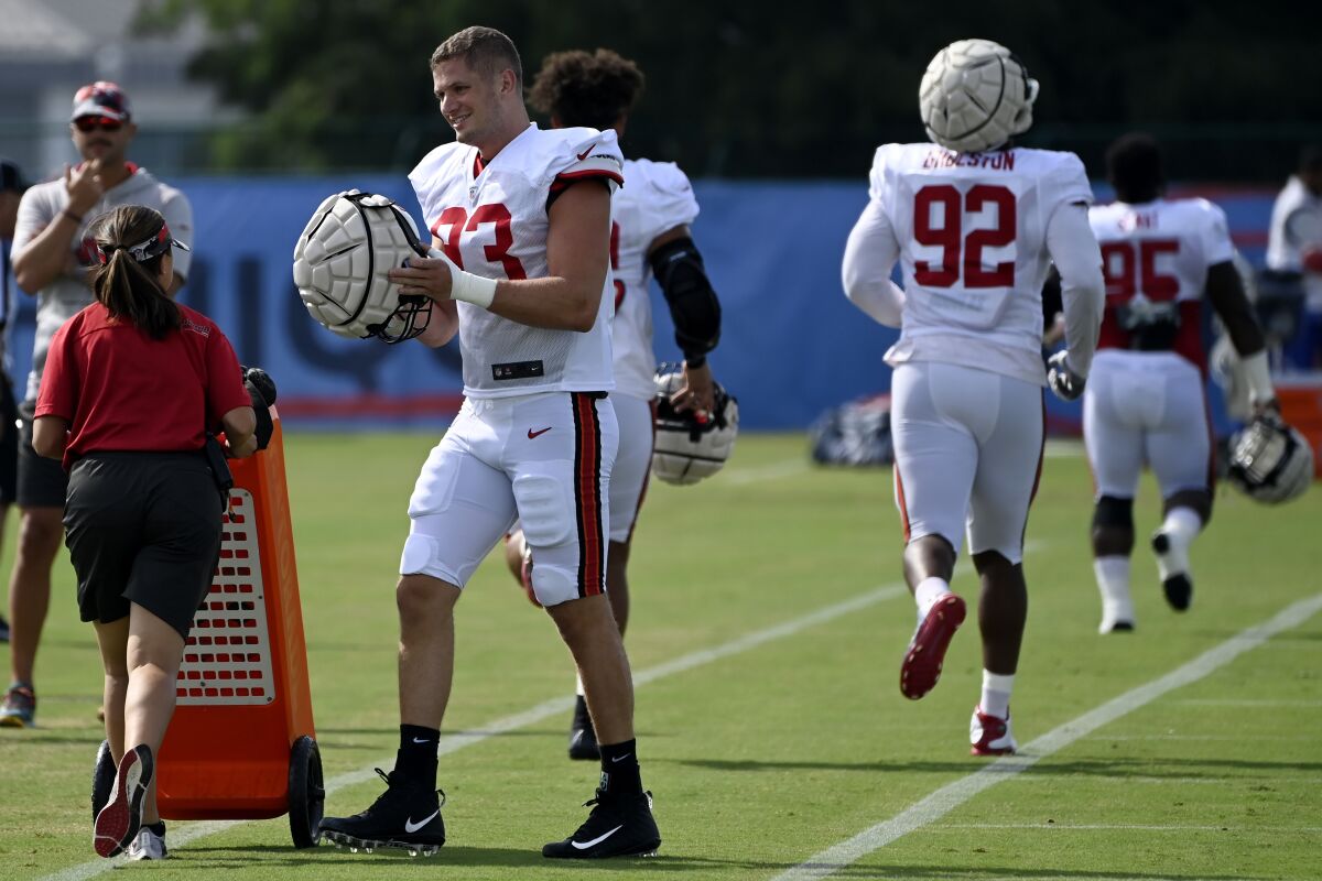 Tampa Bay Buccaneers linebacker Carl Nassib (93) puts his helmet on before taking part in drills during a combined NFL football training camp with the Tennessee Titans Wednesday, Aug. 17, 2022, in Nashville, Tenn. (AP Photo/Mark Zaleski)