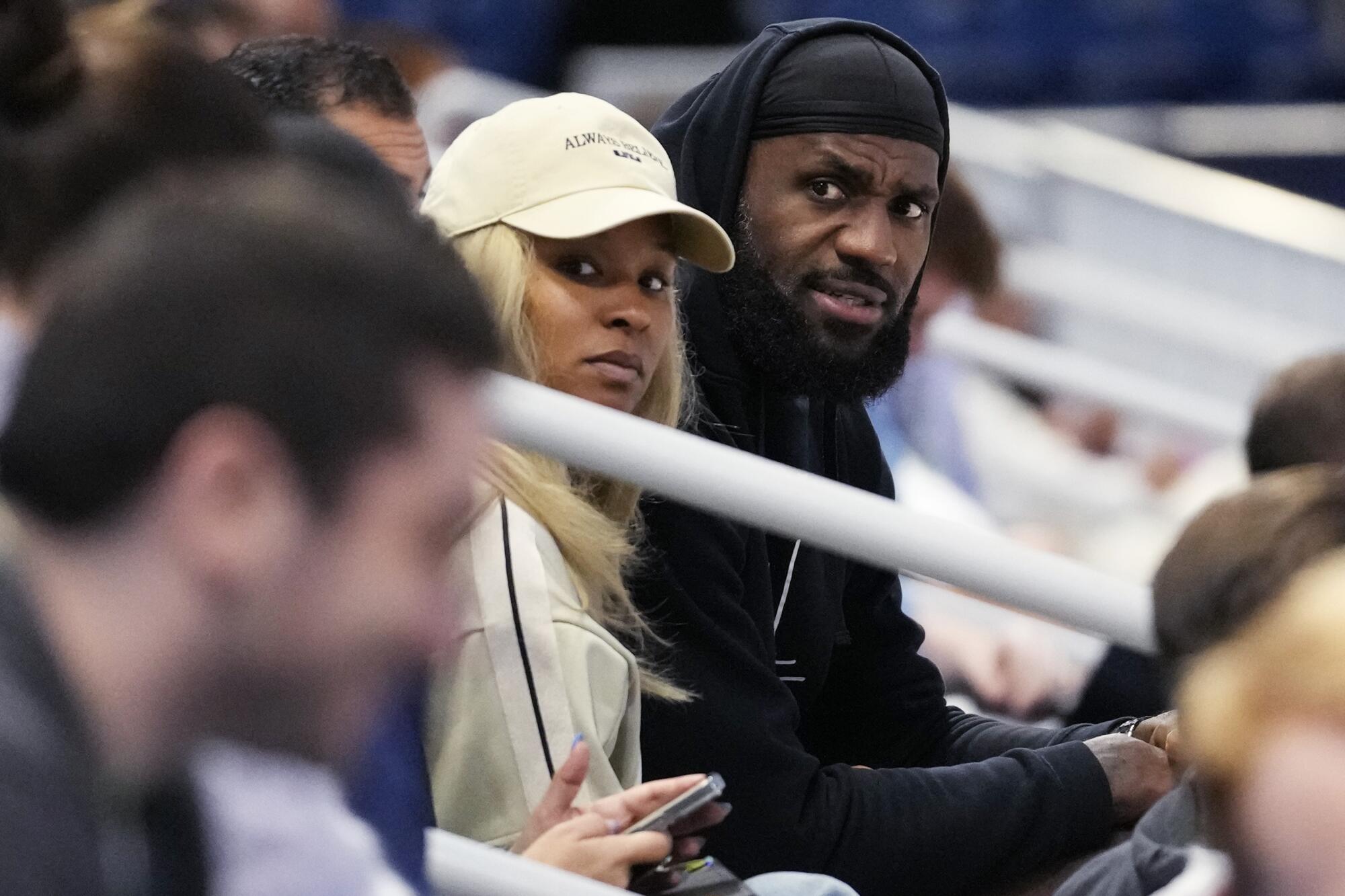 LeBron James (sağda) ve eşi Savannah, NBA Draft'taki mücadele sırasında oğlu Bronny'yi tribünden izliyor.