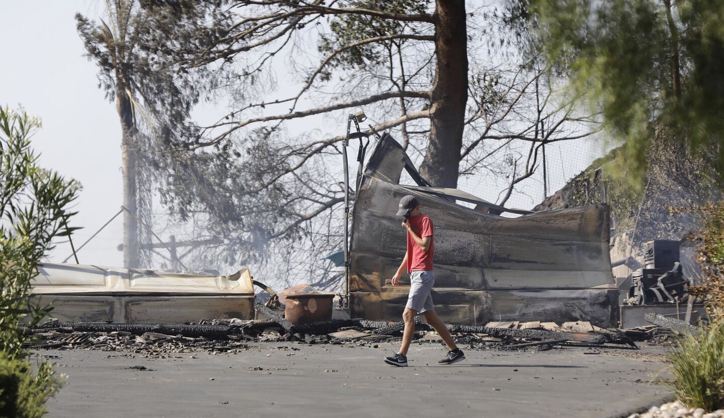 The son of the homeowner of a home on Olive View Road in Alpine walks past what was the front of the family home, a total loss in the West Fire.