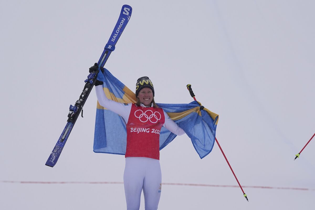 Gold medal winner Sweden's Sandra Naeslund celebrates during the venue award ceremony for the women's cross at the 2022 Winter Olympics, Thursday, Feb. 17, 2022, in Zhangjiakou, China. (AP Photo/Gregory Bull)
