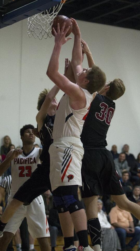 Pacifica Christian High's Josh Griffith, center, grabs an offensive rebound during the first half against Foothill Tech.