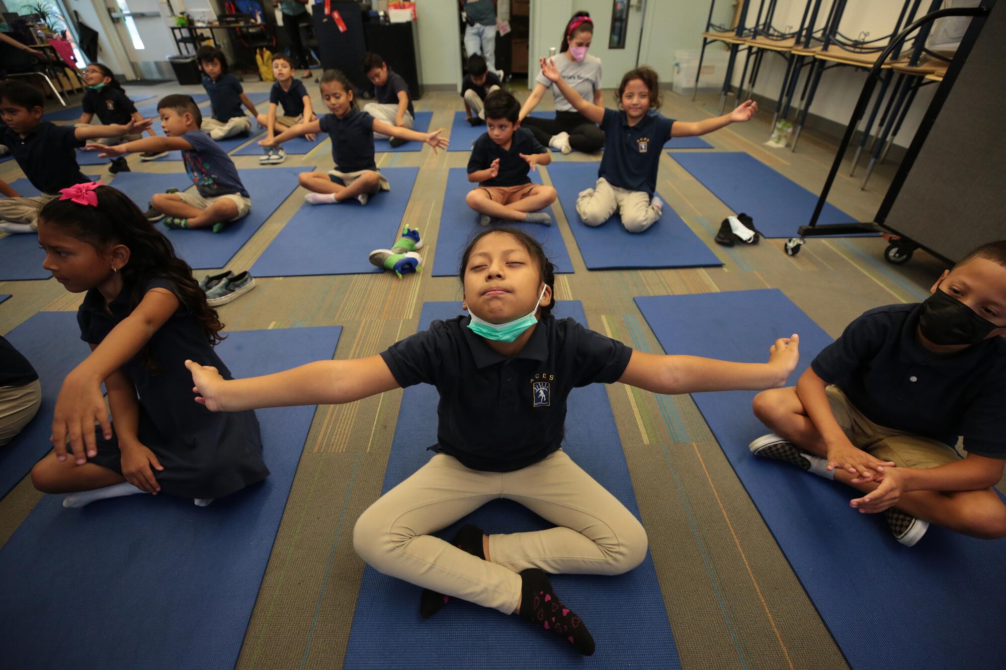 Second grade student Stacy Hernandez-Puac stretches and relaxes to instructions from Yoga instructors