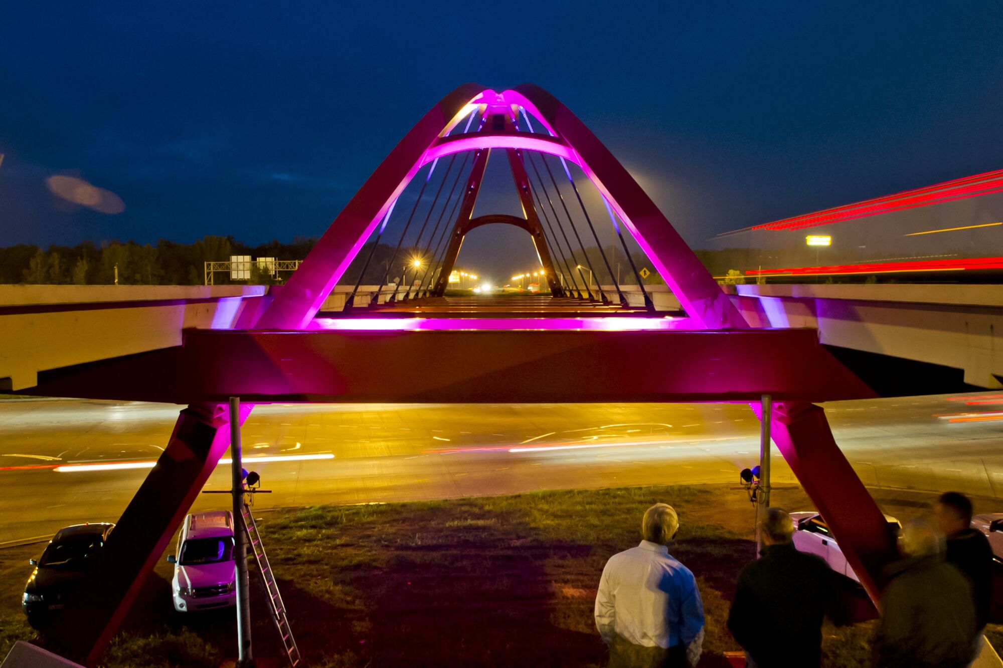 The arched red Front Door Bridge at night over the Interstate 65 and State Road 46 interchange