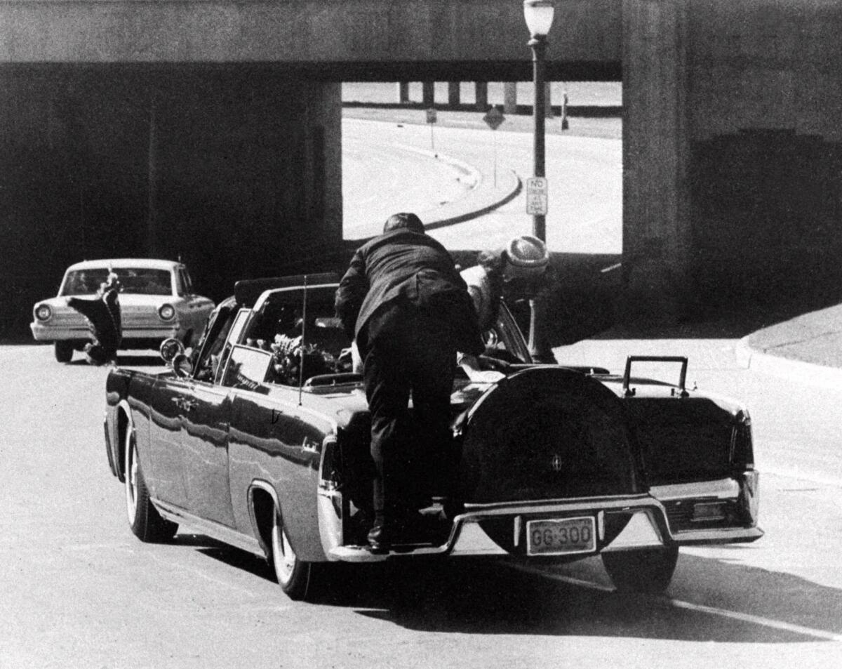 Seconds after the fatal shot, a Secret Service agent climbs aboard the president's limousine as the first lady, her husband slumped over in the backseat, crawls onto the trunk lid.