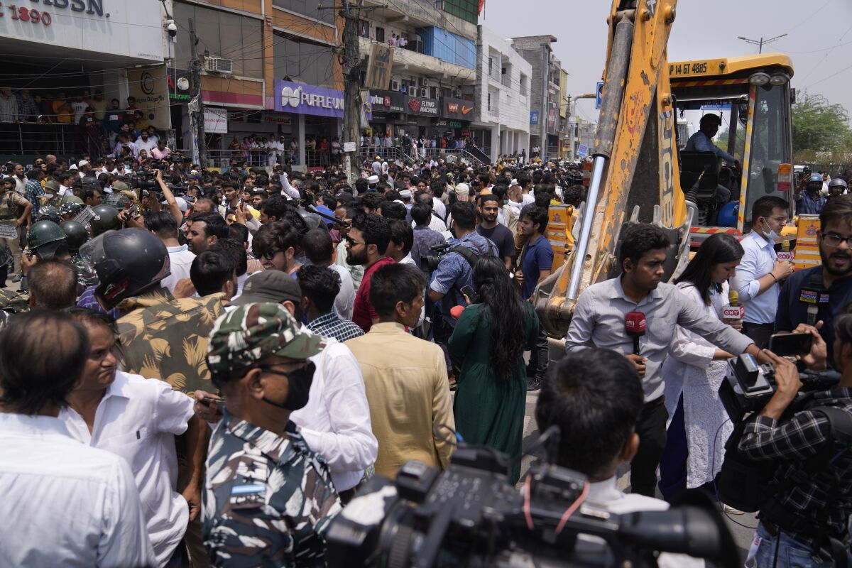 Residents of Shaheen Bagh surround officials during a demolition drive in New Delhi, Monday, May 9, 2022. Authorities in New Delhi stopped a demolition drive in a Muslim-dominated neighborhood after hundreds of residents and a number of opposition party workers gathered in protest Monday. No buildings were razed down before the bulldozers retreated. (AP Photo/Manish Swarup)