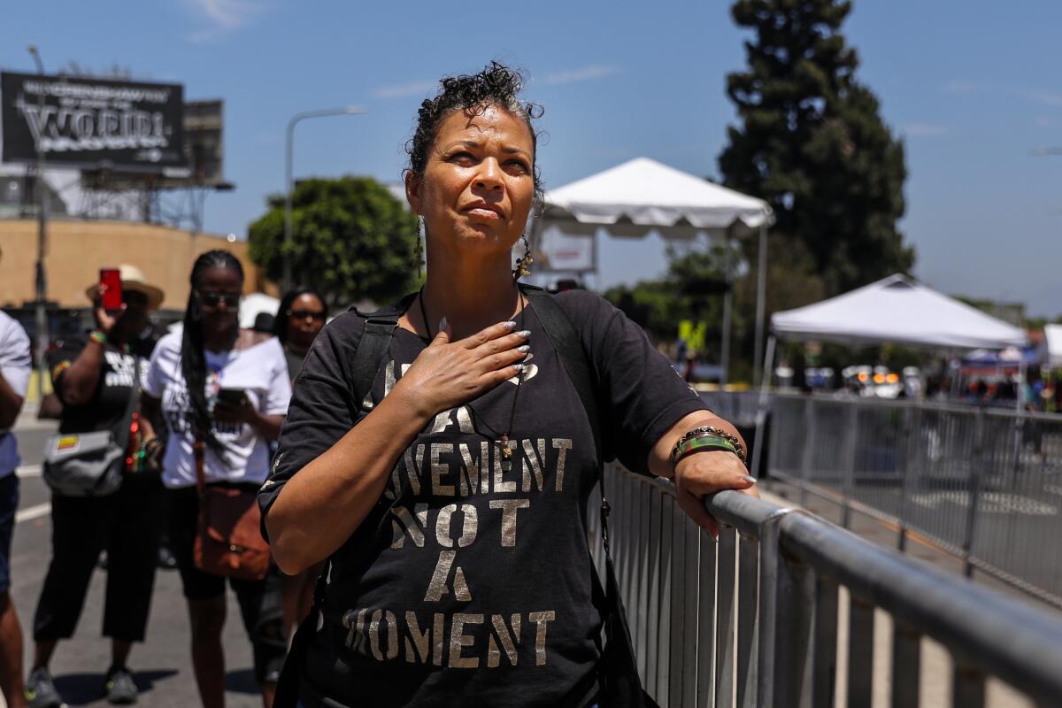 A woman holds a hand to her chest during a festival in Leimert Park.