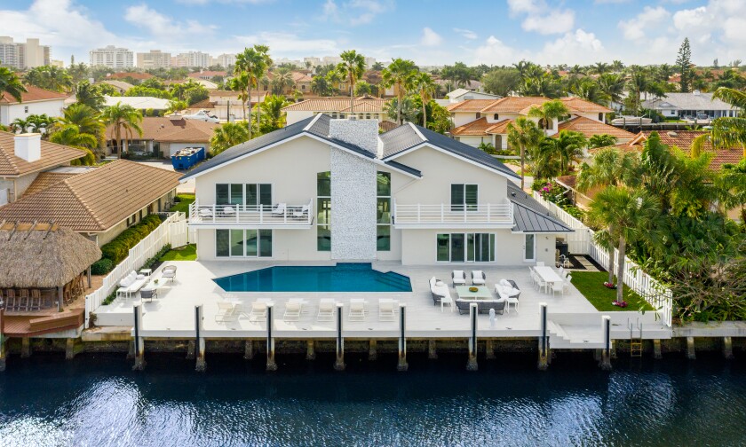 The modern home has an expansive patio with 90 feet of water frontage.