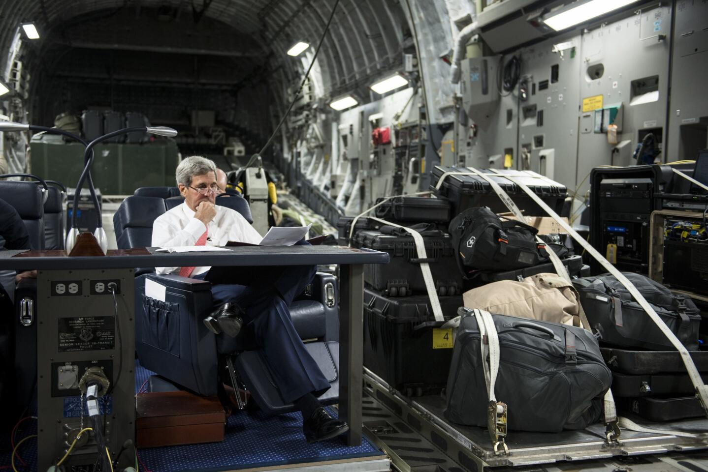 Secretary of State John Kerry looks over papers while flying from Jordan to Iraq on September 10.