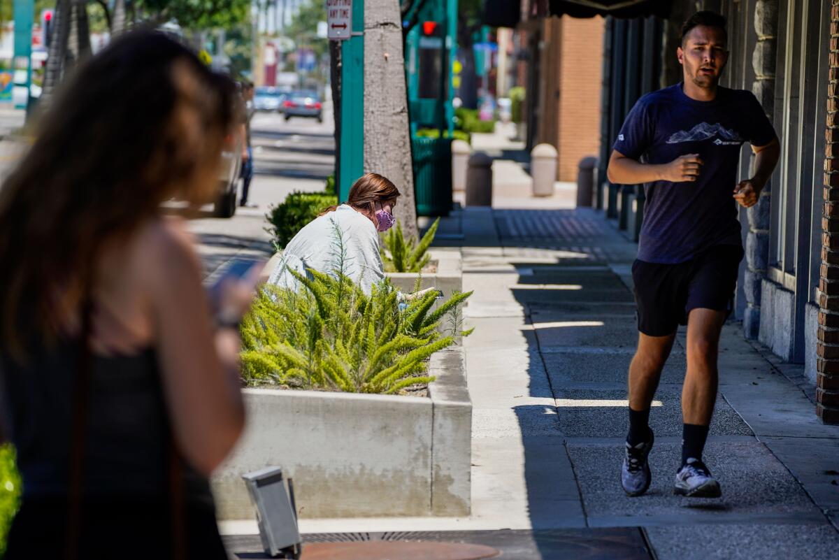 A man jogs along Harbor Boulevard in downtown Fullerton last week after Orange County rescinded its mask order.