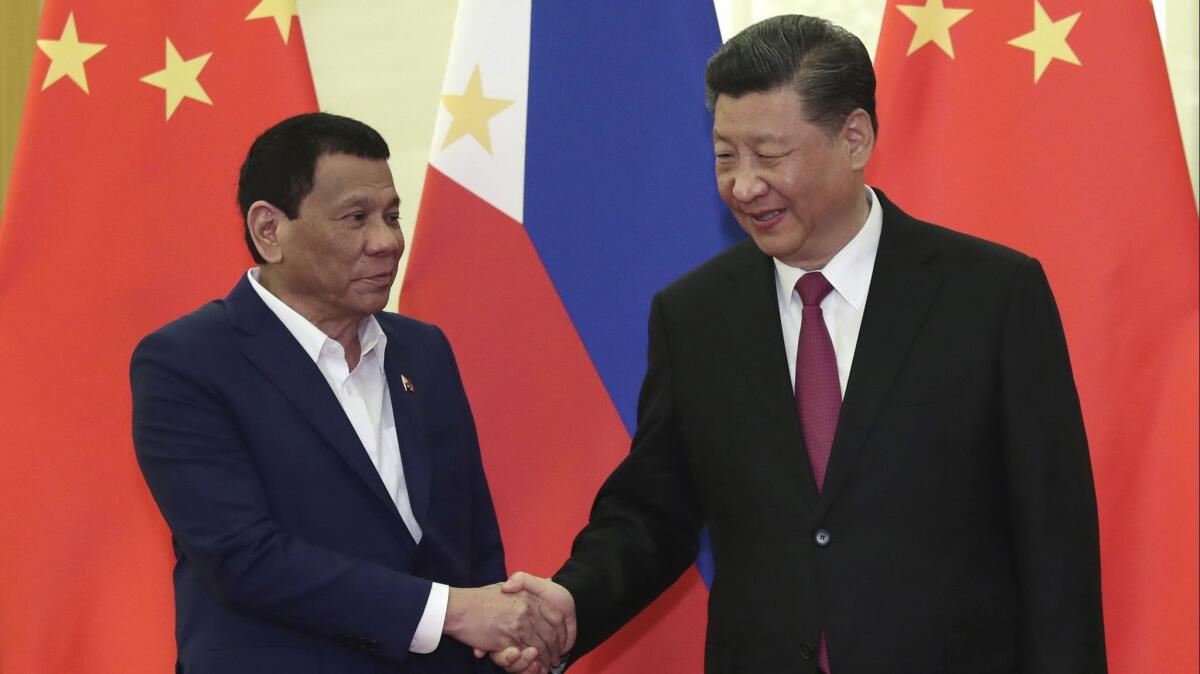 Philippine President Rodrigo Duterte, left, shakes hands with Chinese President Xi Jinping before a trade meeting in Beijing in April 2019.