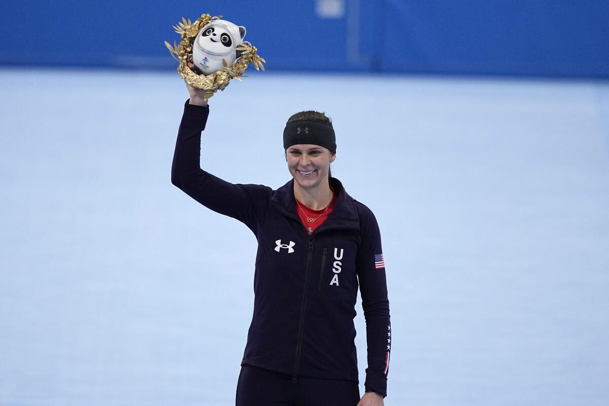 Brittany Bowe holds up her trophy at the 2022 Olympics.