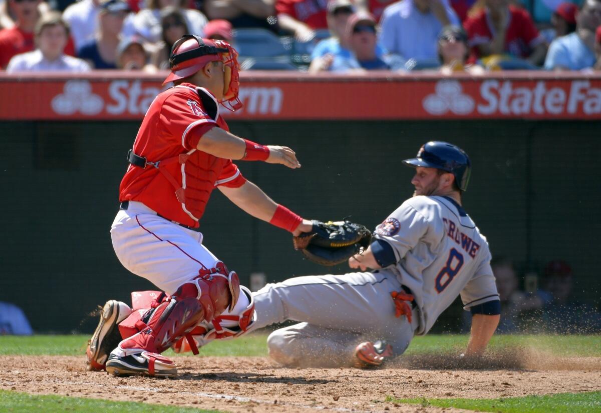 Angels catcher Hank Conger, left, tags out Houston's Trevor Crowe at home plate during a game on June 2. Conger has made a difference for the Angels behind home plate.