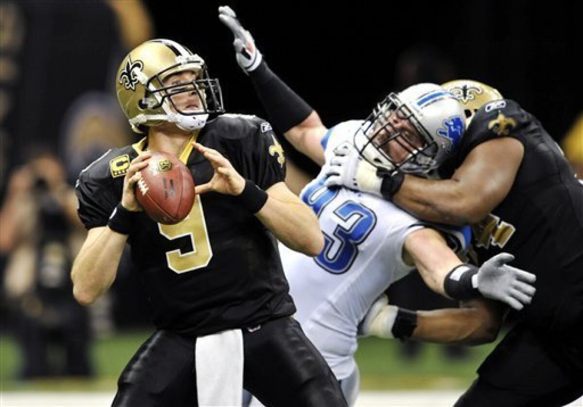 New Orleans Saints quarterback Drew Brees (9) passes as Detroit Lions defensive end Kyle Vanden Bosch (93) is held by New Orleans Saints offensive tackle Jermon Bushrod (74) during the fourth quarter of an NFL football game in New Orleans, Sunday, Dec. 4, 2011. Brees passed for 342 yards and three touchdowns, giving him 4,031 yards on the season and making him the first quarterback in NFL history to eclipse the 4,000-yard mark in the first 12 games of the season. The Saints won 31-17. (AP Photo/Bill Feig)