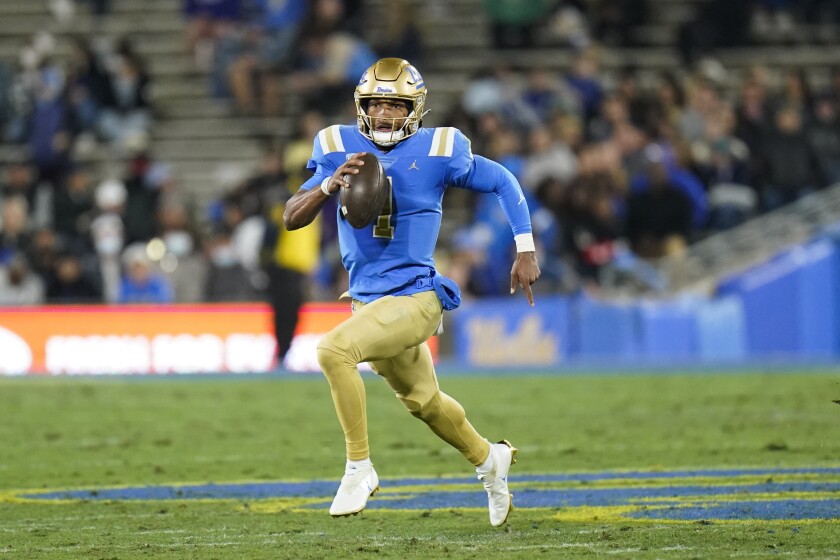 quarterback UCLA Dorian Thompson-Robinson menjalankan bola melalui babak pertama.