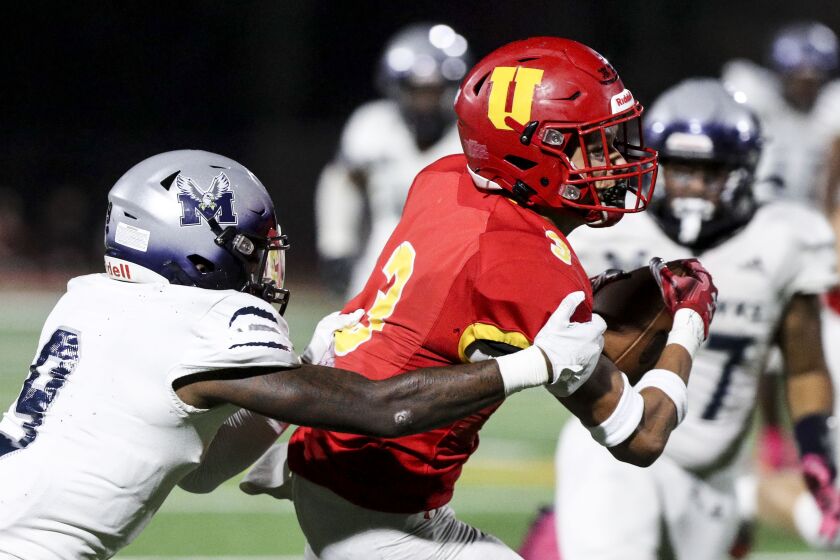 San Diego, CA - October 07: Madison's Jaylon Brown (9) attempts to take down Cathedral Catholic's Marcus Ratcliffe (3) during their game at Cathedral Catholic High School on Friday, Oct. 7, 2022 in San Diego, CA. (Meg McLaughlin / The San Diego Union-Tribune)