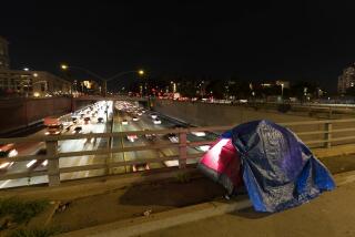 FILE - In this photo illuminated by an off-camera flash, a tarp covers a portion of a homeless person's tent on a bridge overlooking the 101 Freeway in Los Angeles, Thursday, Feb. 2, 2023. The United States experienced a dramatic 12% increase in homelessness as soaring rents and a decline in coronavirus pandemic assistance combined to put housing out of reach for more Americans, federal officials said Friday, Dec. 15, 2023. (AP Photo/Jae C. Hong, File)