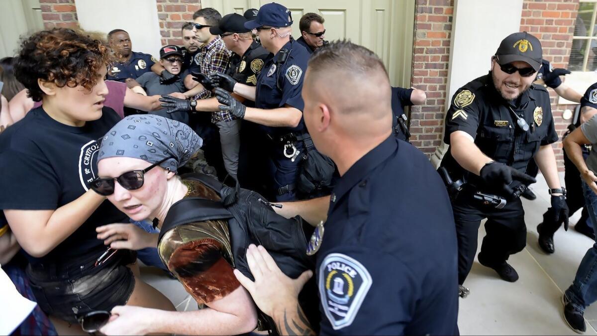 Protesters scuffle with police during a rally Saturday at the University of North Carolina in Chapel Hill, N.C. The rally featured those for and against the removal of the controversial "Silent Sam" statue, which was toppled earlier this week.