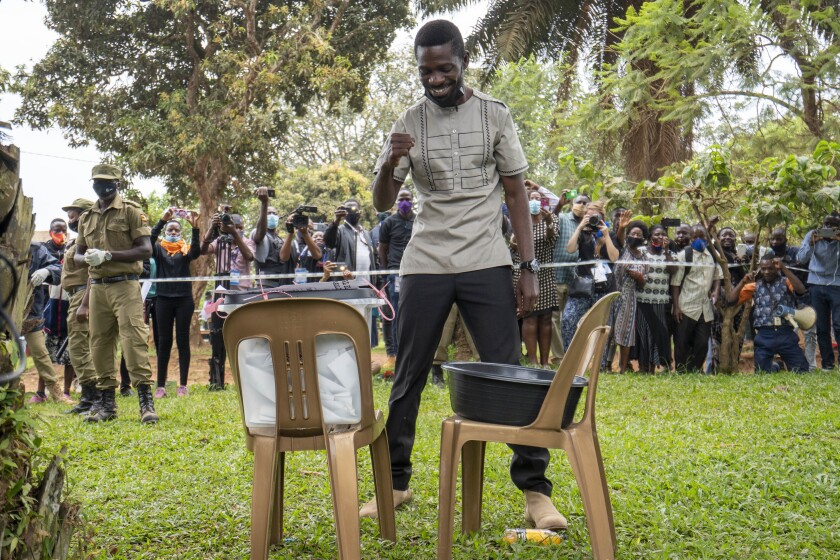 Uganda's leading opposition challenger Bobi Wine reacts after voting in Kampala, Uganda, Thursday, Jan. 14, 2021. Ugandans are voting in a presidential election tainted by widespread violence that some fear could escalate as security forces try to stop supporters of Wine from monitoring polling stations.(AP Photo/Jerome Delay)