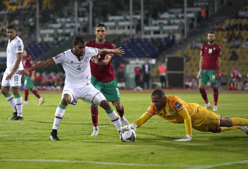 Comoros' Younn Zahary,left, defends against Morocco's Achraf Hakimi,middle, as the teammate goalkeeper Salim Ben Boina collects the ball during the African Cup of Nations 2022 group C soccer match between Morocco and Comoros at the Ahmadou Ahidjo stadium in Yaounde, Cameroon, Friday, Jan. 14, 2022. (AP Photo/Themba Hadebe)