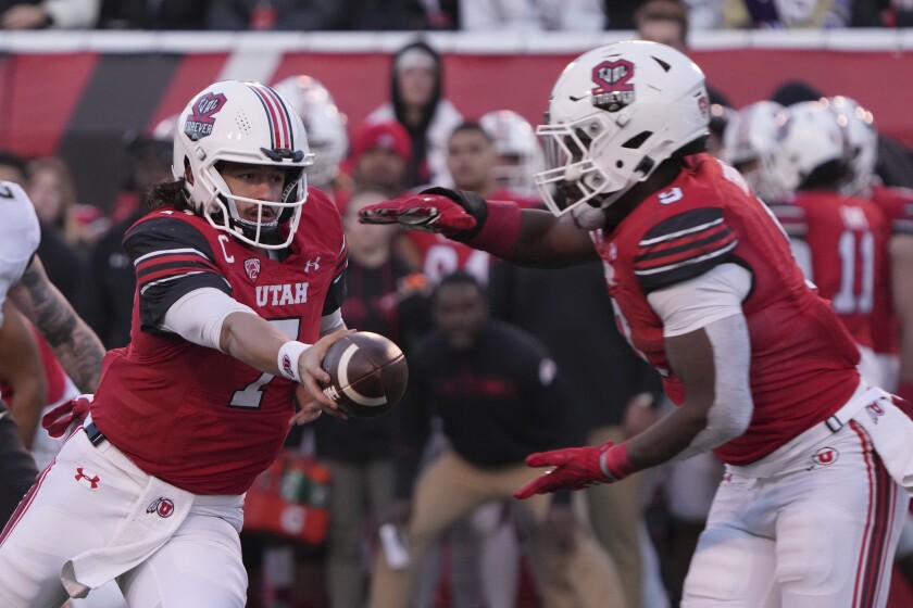 Utah quarterback Cam Rising hands off the ball to running back Tavion Thomas.