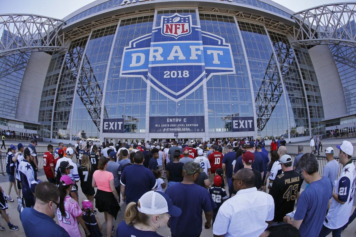 People wait to get into the stadium for the second round of the NFL football draft on Friday.