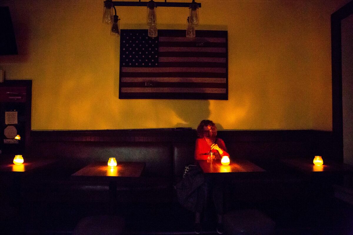 Woman sitting at a table with a candle during a blackout