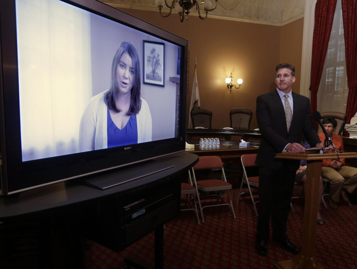 During a March 25 appearance at the California Capitol, Dan Diaz, the husband of Brittany Maynard, watches a video of his wife recorded 19 days before her assisted-suicide death. Diaz was at the Capitol again on Aug. 18, urging support for an aid-in-dying bill.